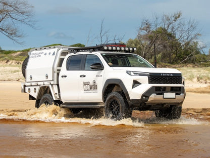 Toyota Hilux équipé d’une galerie RHINO-RACK lors d’un franchissement dans l’eau